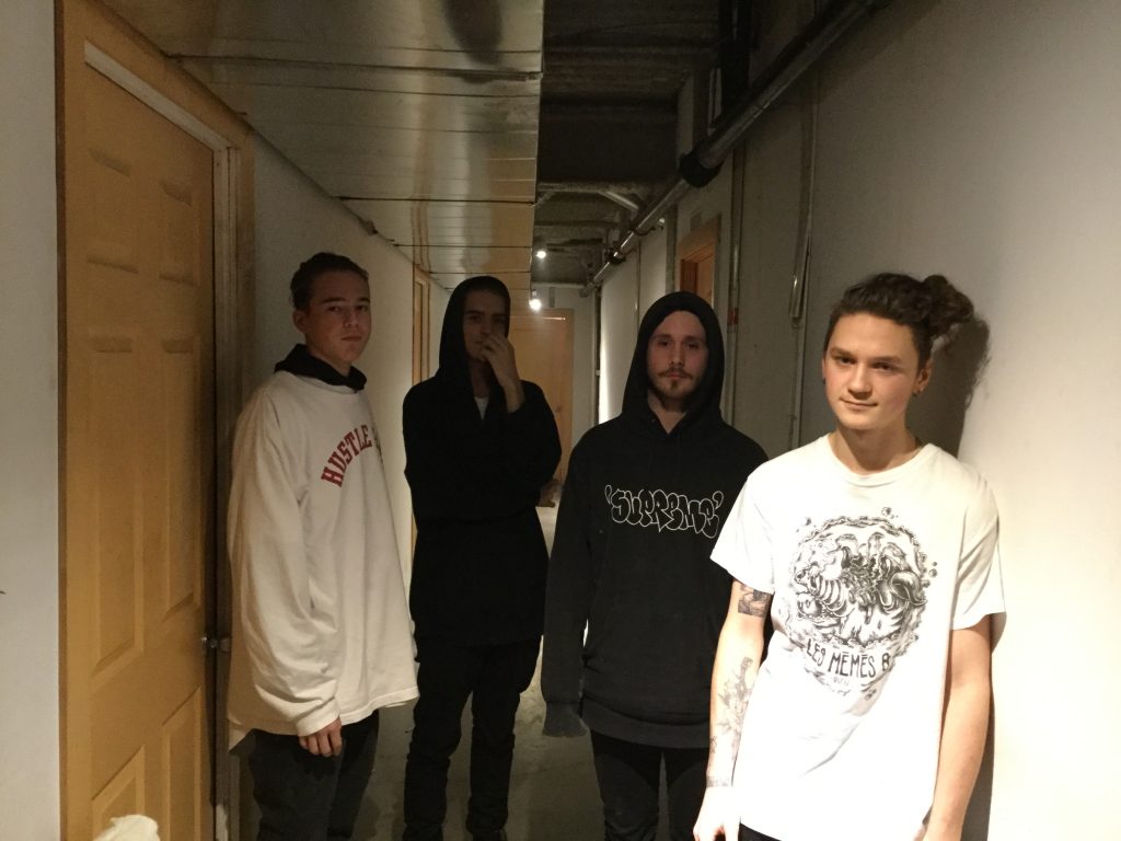 Les 4 gars du collectif Team XXI se tiennent dans un couloir.